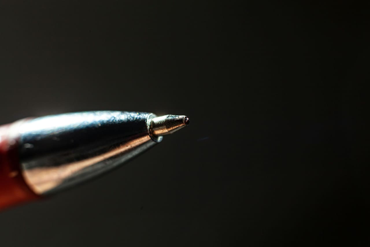 Macro view of a ballpoint pen tip against a dark background